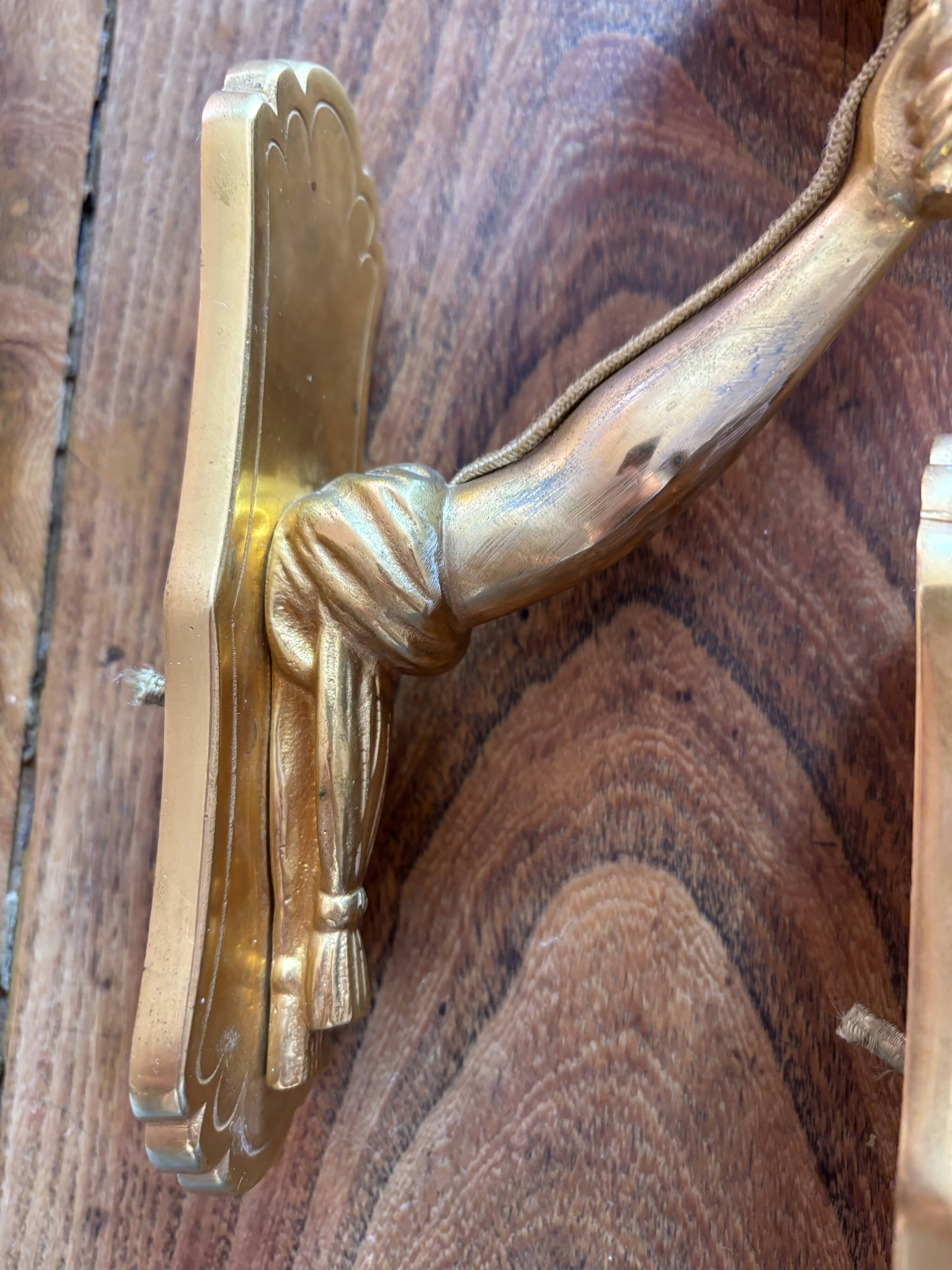 Pair of bronze wall sconces with outstretched arms and hands