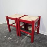 Red wooden stool with woven rush seat.