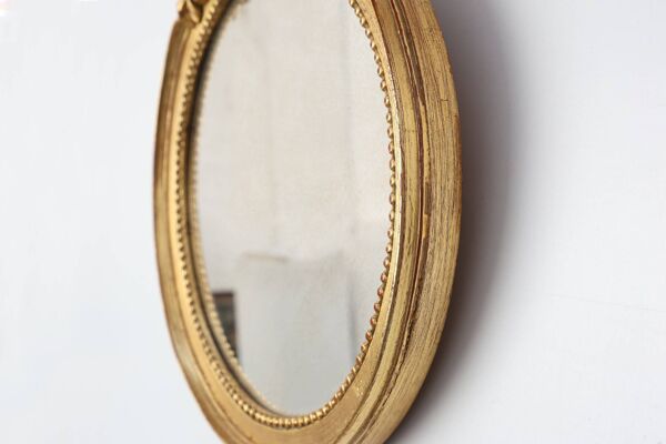 Miroir ovale en bois doré avec un fronton floral de style rococo, milieu du 20e siècle