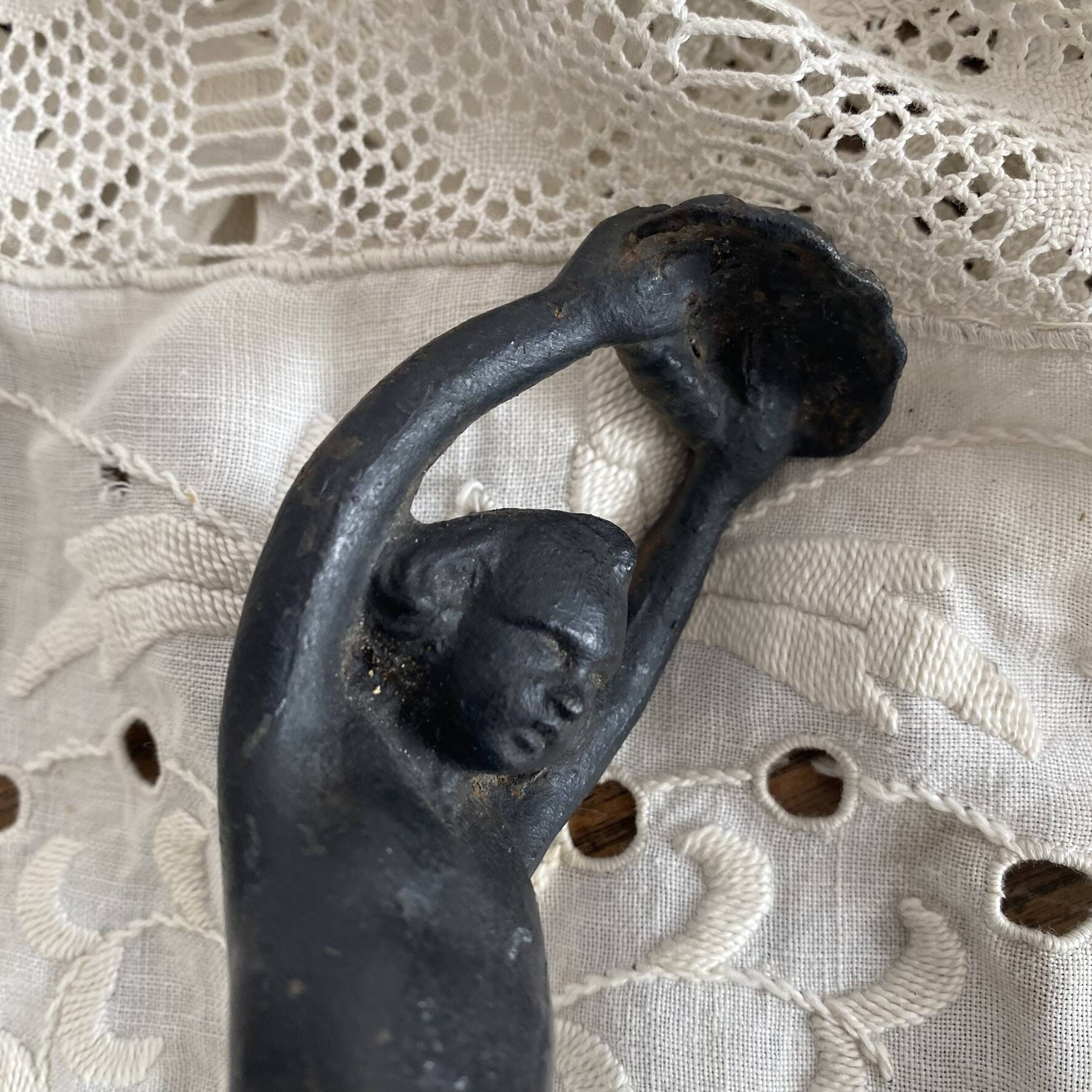 Antique cast iron coat hook with swimmer and shell basin.