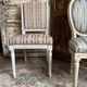 Pair of Louis XVI style chairs in painted wood and satin, classic elegance.