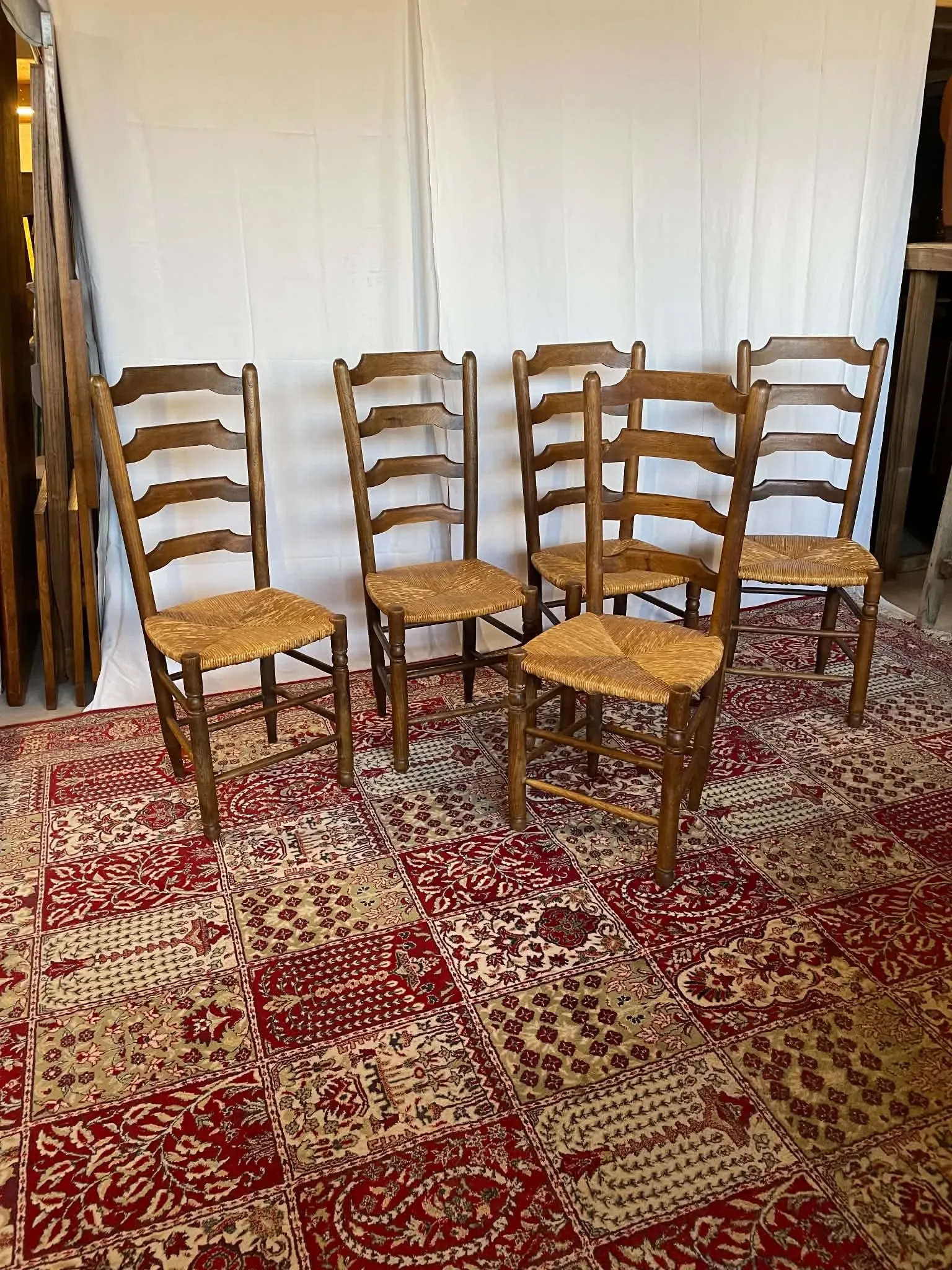 Set of 5 antique solid oak chairs with straw seats.