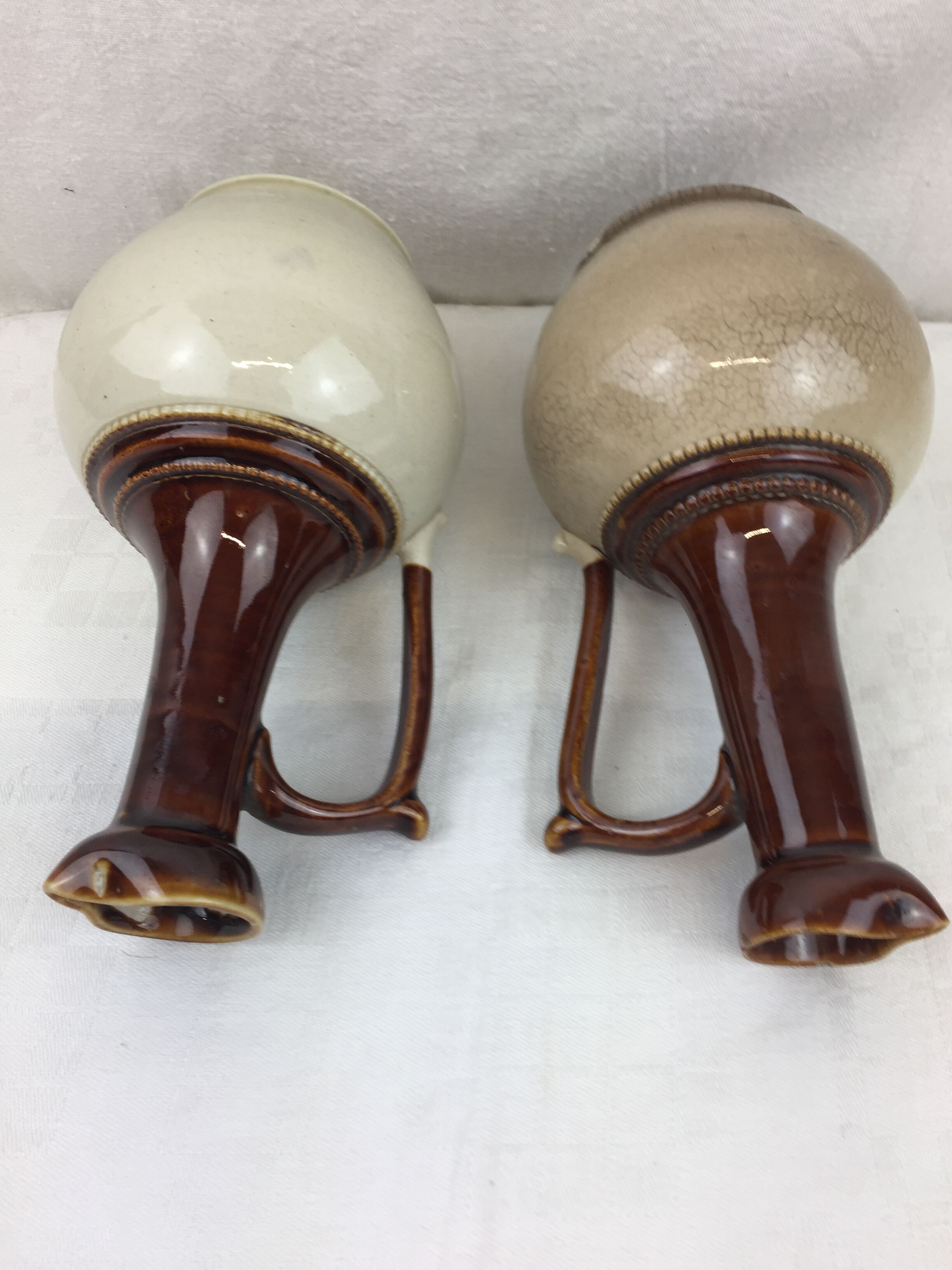 Antique handmade pitchers in beige and brown enamelled terracotta