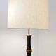 Tripod floor lamp in wrought iron and brass with bamboo-style base.