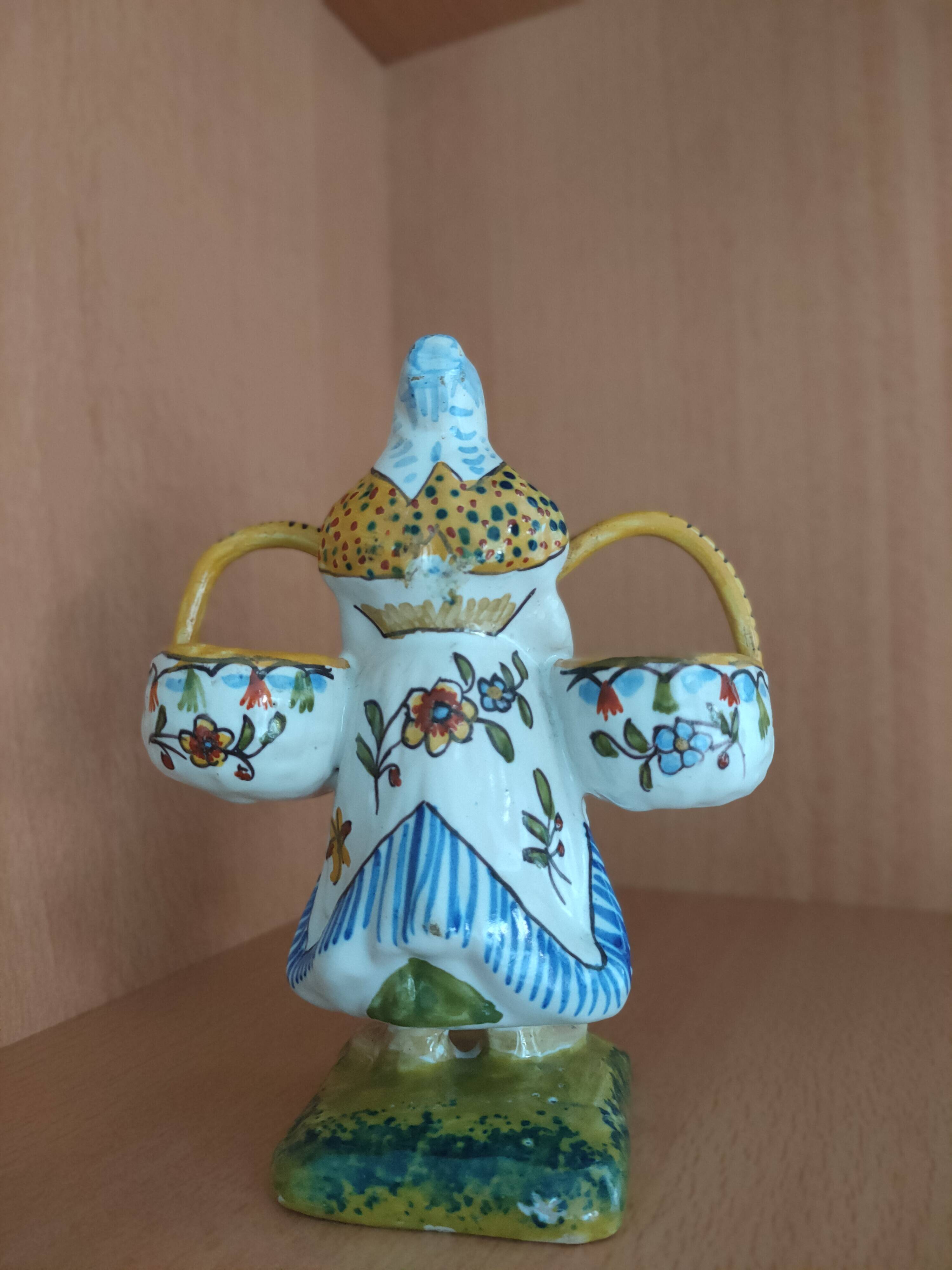 Antique earthenware salt cellar with a woman with baskets
