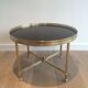 Round coffee table in brass with a black lacquered glass top by Maison Jansen.