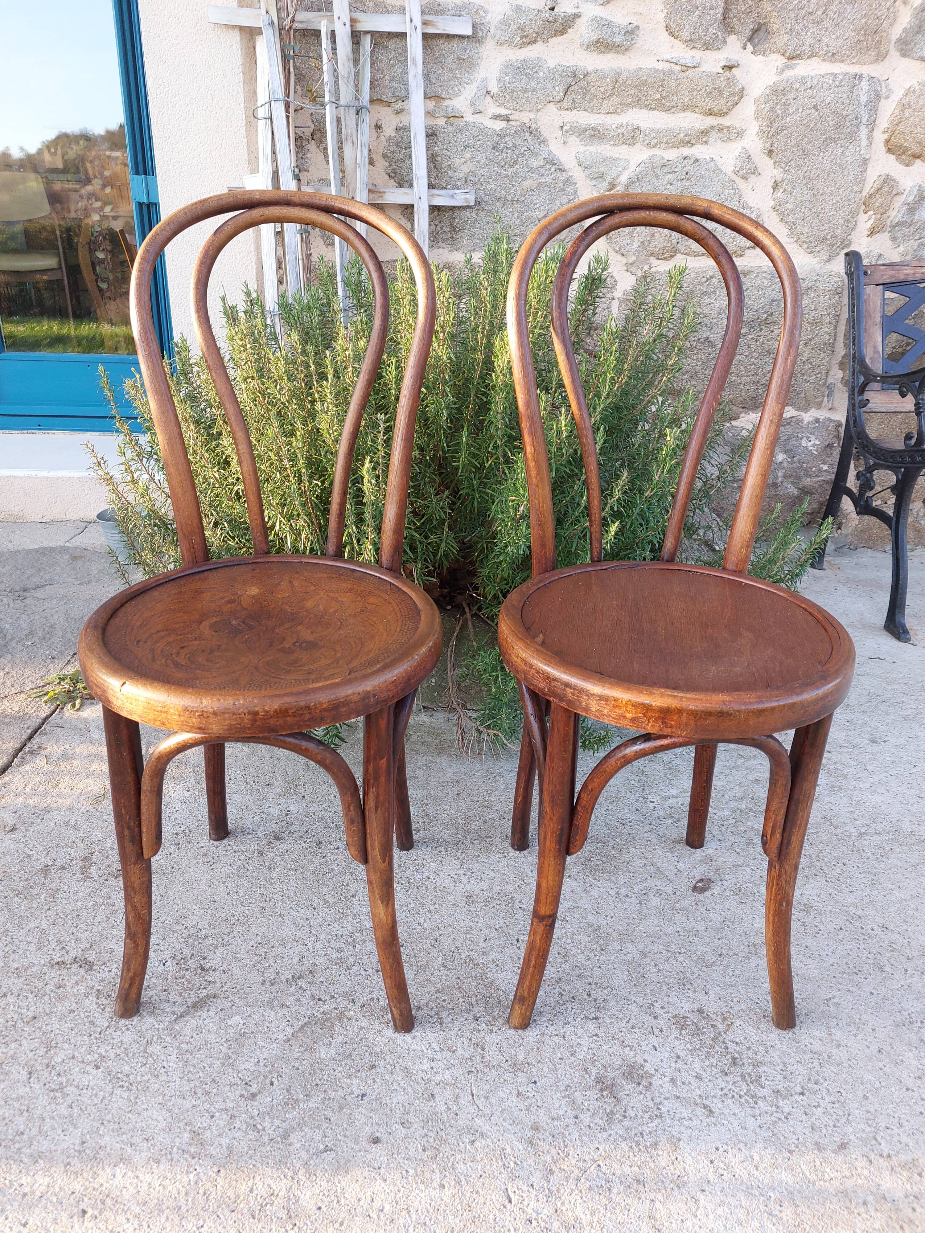 pair of round wooden chairs with a pattern on the seat