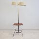 Brass and lacquered metal floor lamp with a wooden magazine shelf.