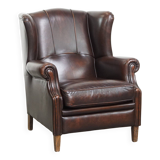 Comfortable wingback chair in English style made of cowhide leather