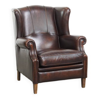 Comfortable wingback chair in English style made of cowhide leather