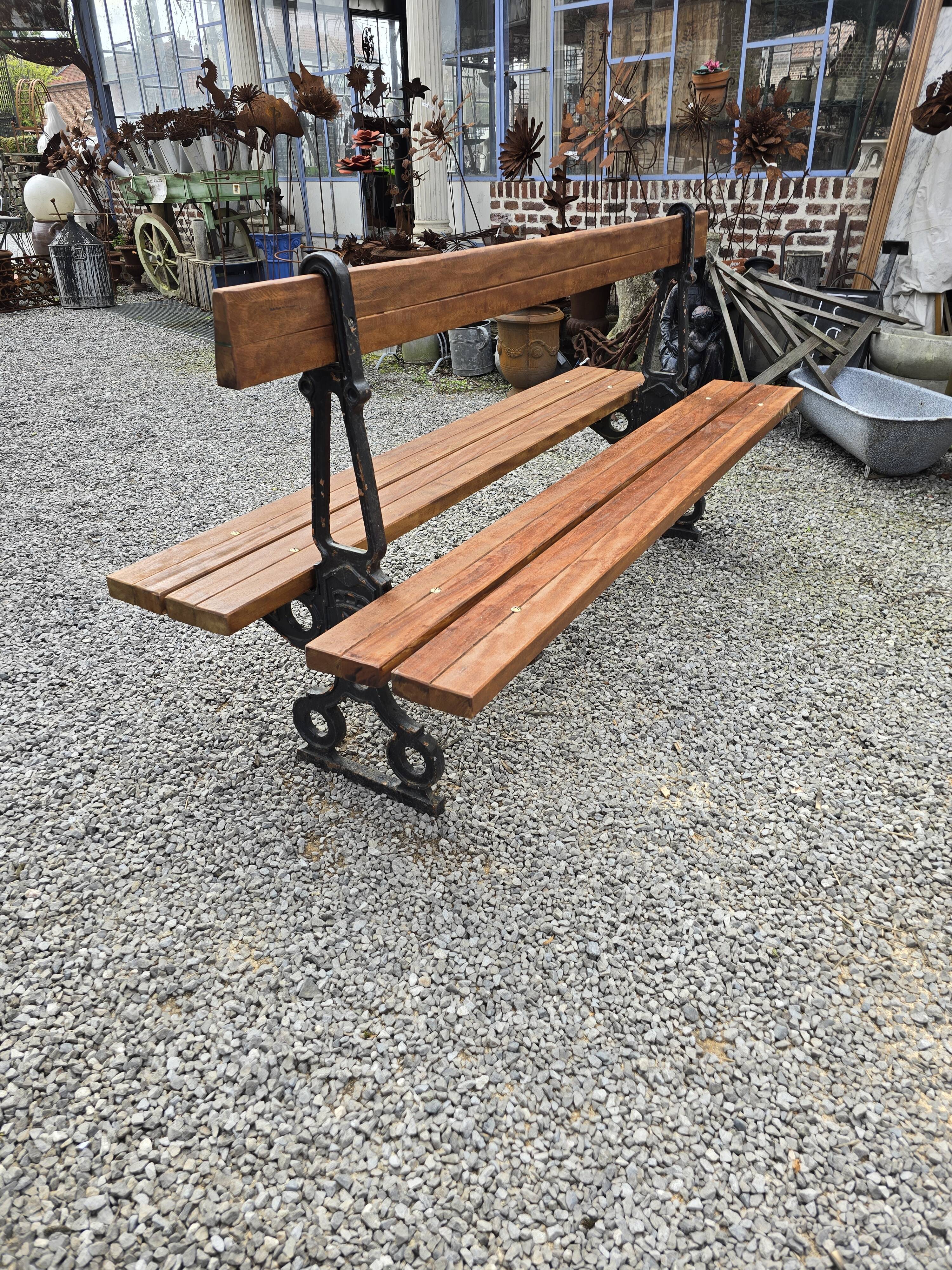 Antique double garden bench from the city of Paris in cast iron and wood