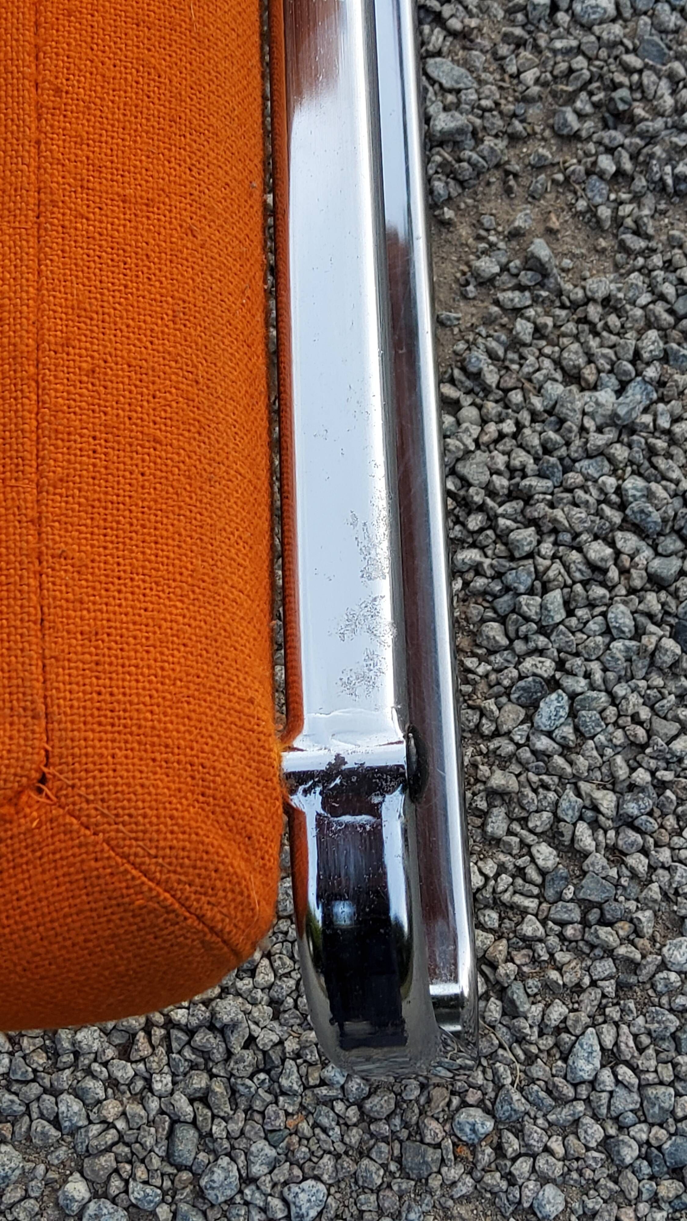 Pair of designer armchairs in orange fabrics and chrome tubes from the 70s