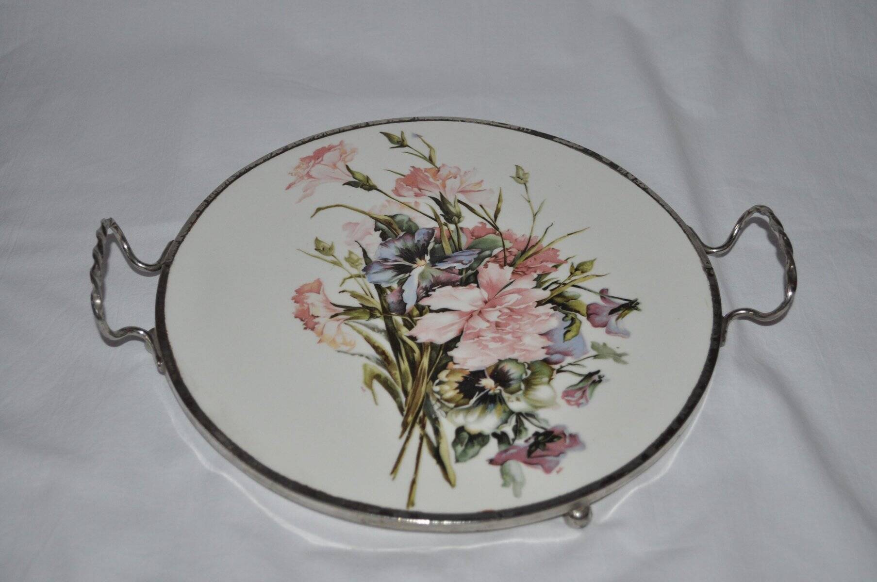 Round white porcelain and metal cake stand, floral decoration, antique style.