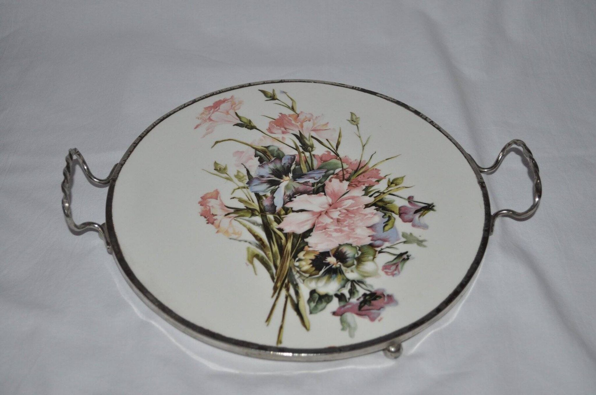 Round white porcelain and metal cake stand, floral decoration, antique style.