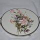 Round white porcelain and metal cake stand, floral decoration, antique style.