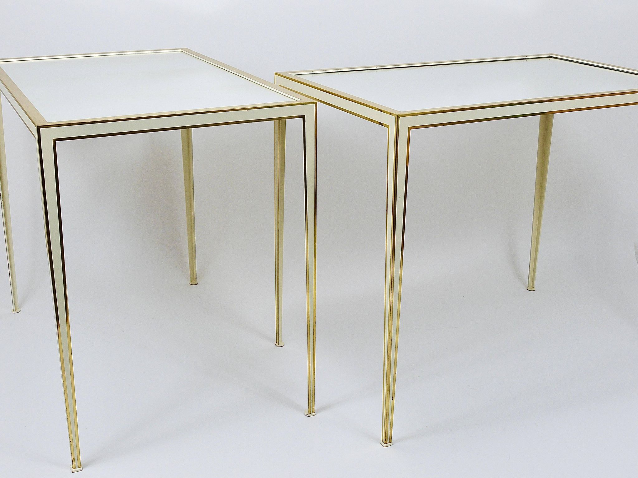 A pair of brass and white mirror tables from Vereinigte Werkstätten, Germany, 1970s.