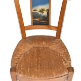 Pair of chairs with slatted backs and painted bands depicting animated landscapes.
