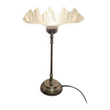 Table lamp with a silver base and a scalloped shade.