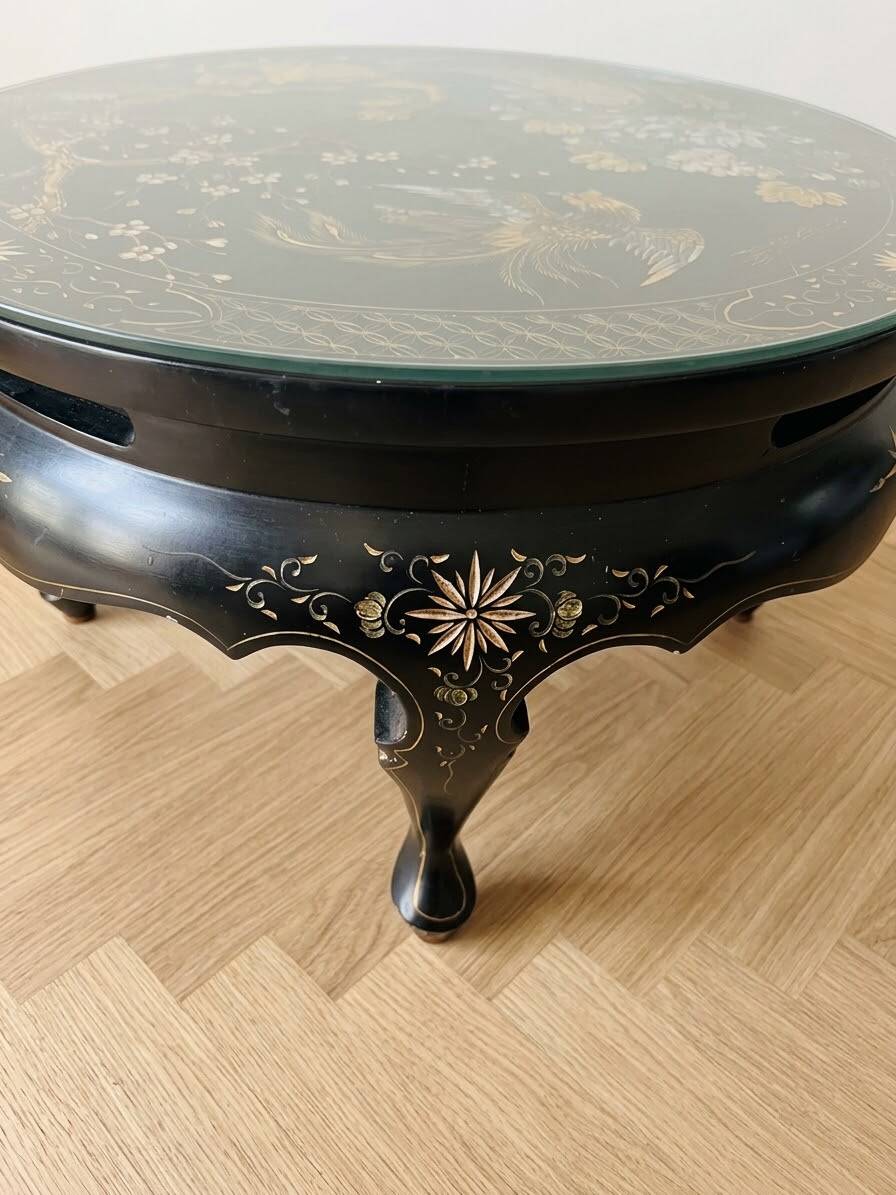 Asian coffee table in Chinese style made of black and gold lacquered wood.