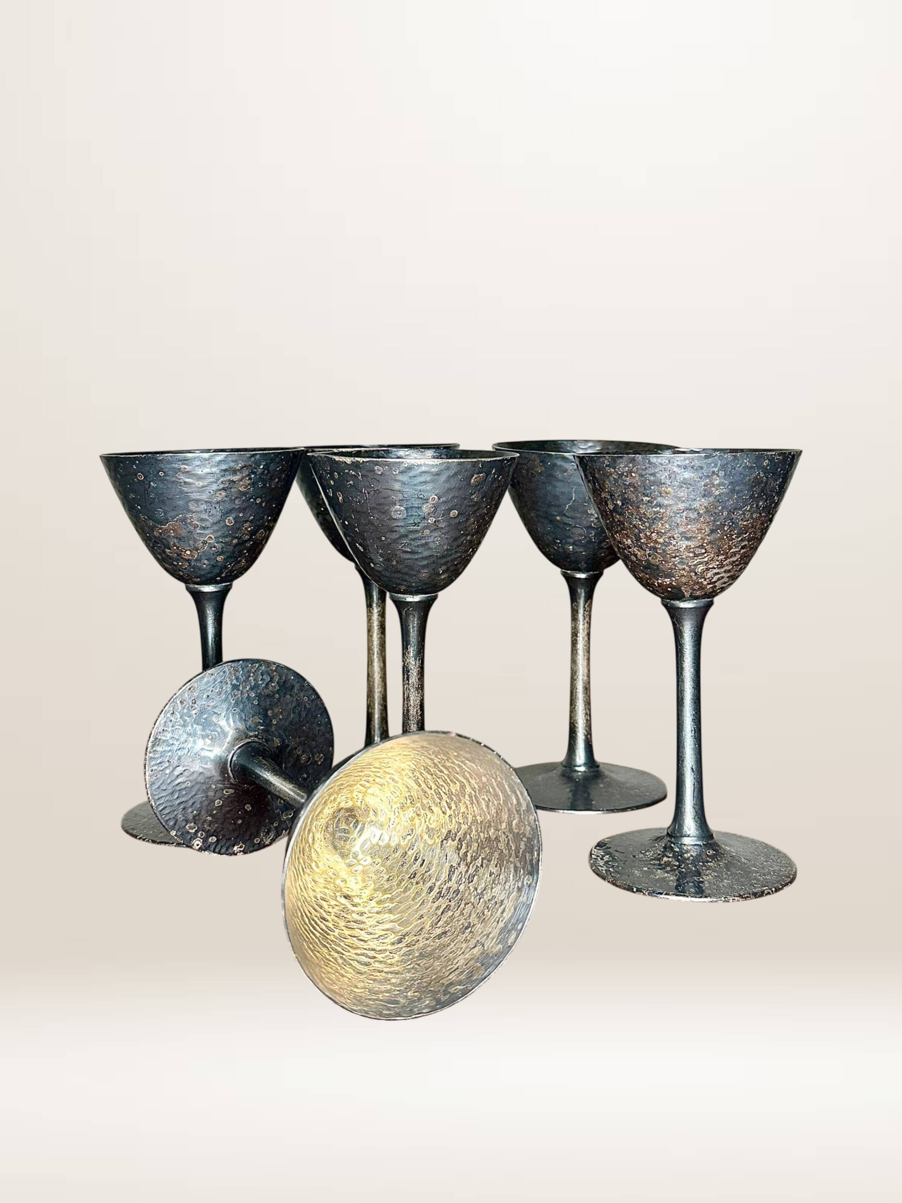 Set of six hammered metal goblets.