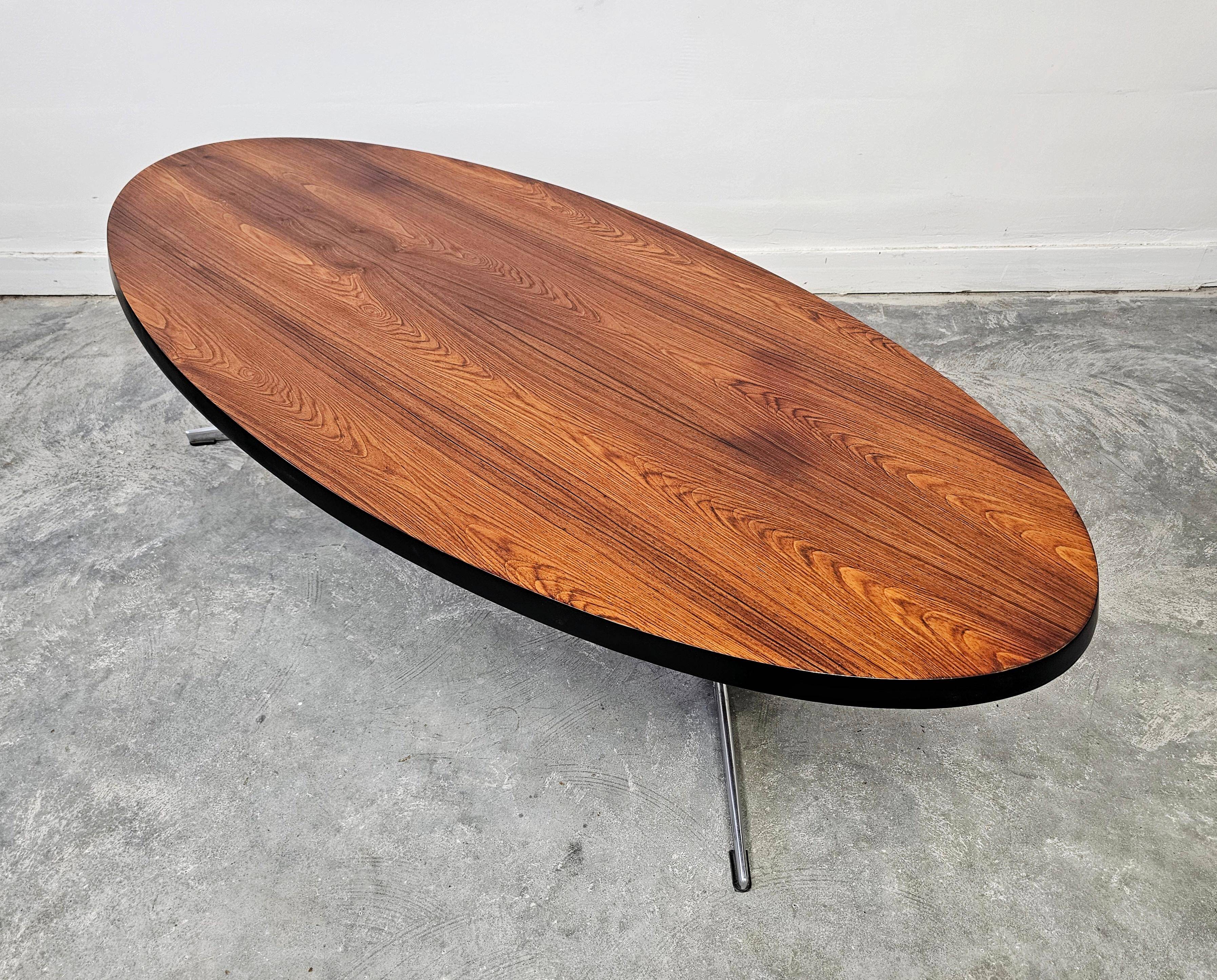Danish Mid Century Modern oval coffee table with a teak top and chrome legs.