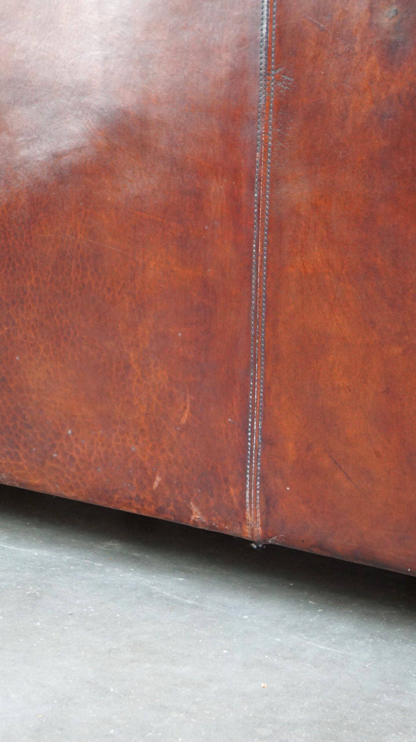 Canapé en cuir de mouton 2,5 places, luxueux et confortable, avec des coussins en tissu.