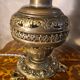 brass and bronze lamp with an antique base from 1900 and a glass paste shade