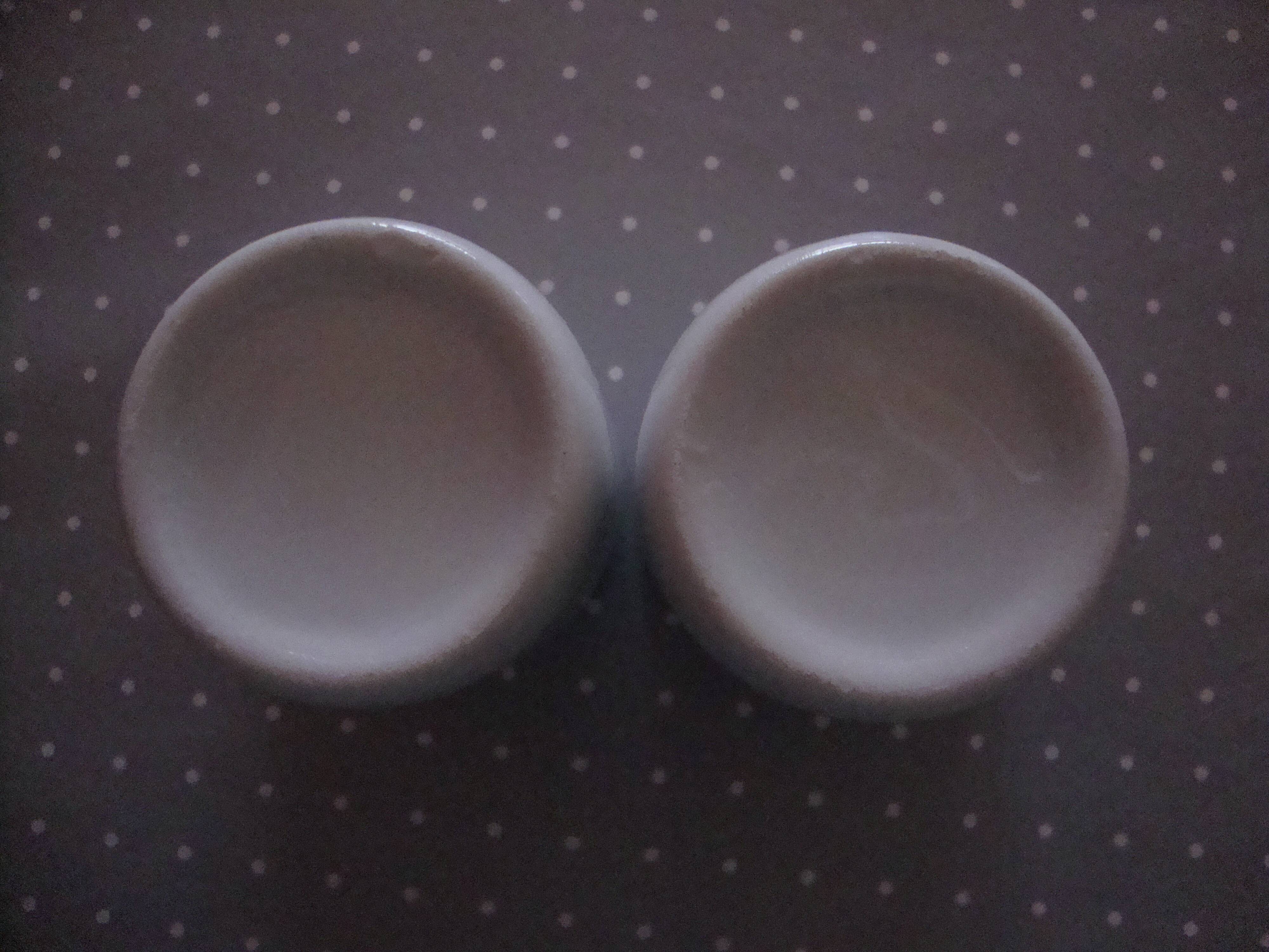 Duo of white ceramic coffee cups metal support