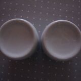 Duo of white ceramic coffee cups metal support