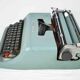 Machine à écrire Olivetti Studio 44 dans son étui avec la clef du coffret