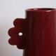 Handmade abstract ceramic vase with asymmetrical handles and burgundy flower