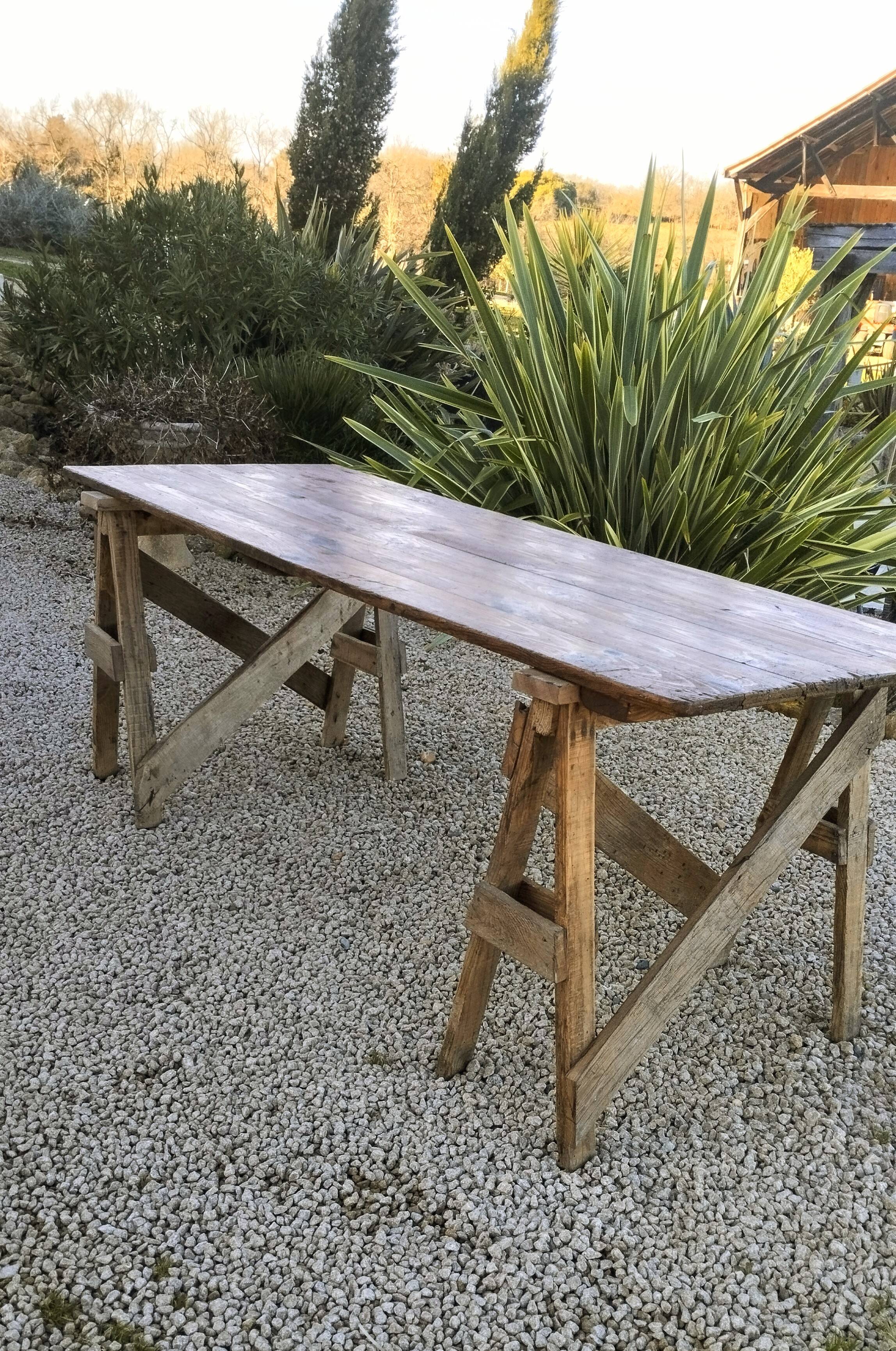 Table de ferme rustique patinée sur de lourds tréteaux