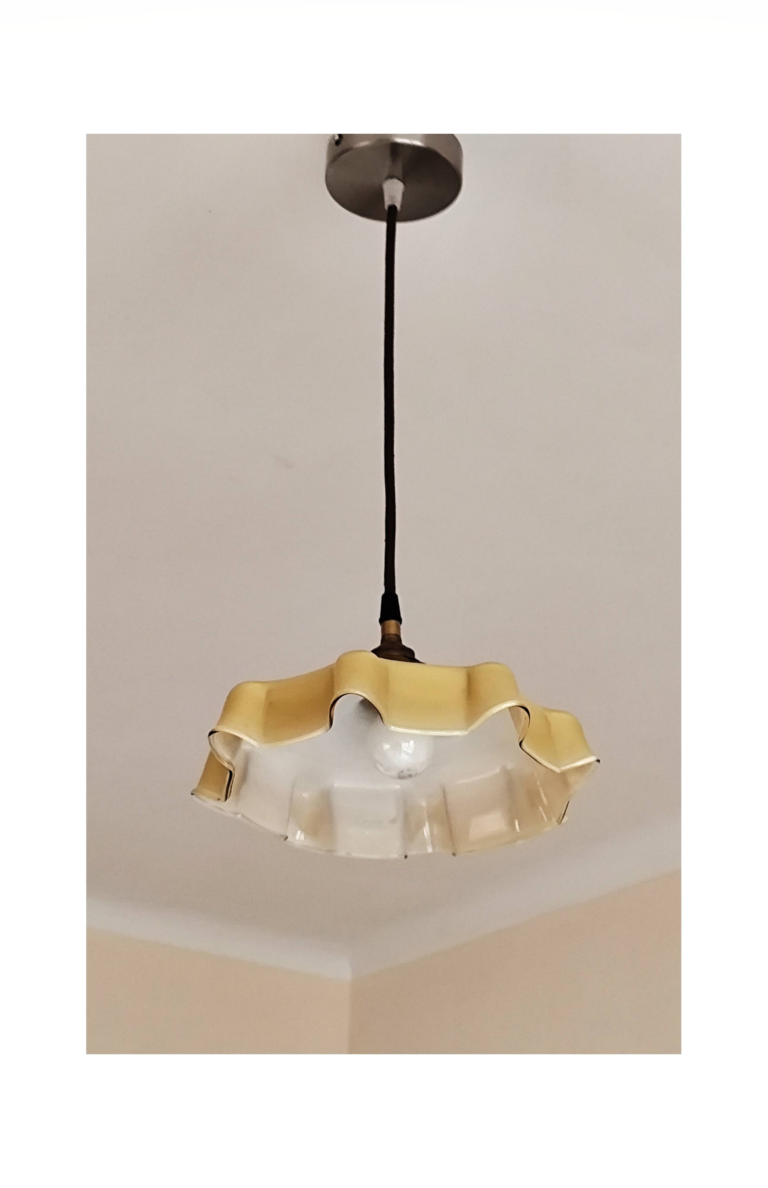 Electrified suspension with a frosted opaque glass disc shade.