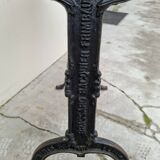 Solid oak bistro table with a cast iron base, signed.