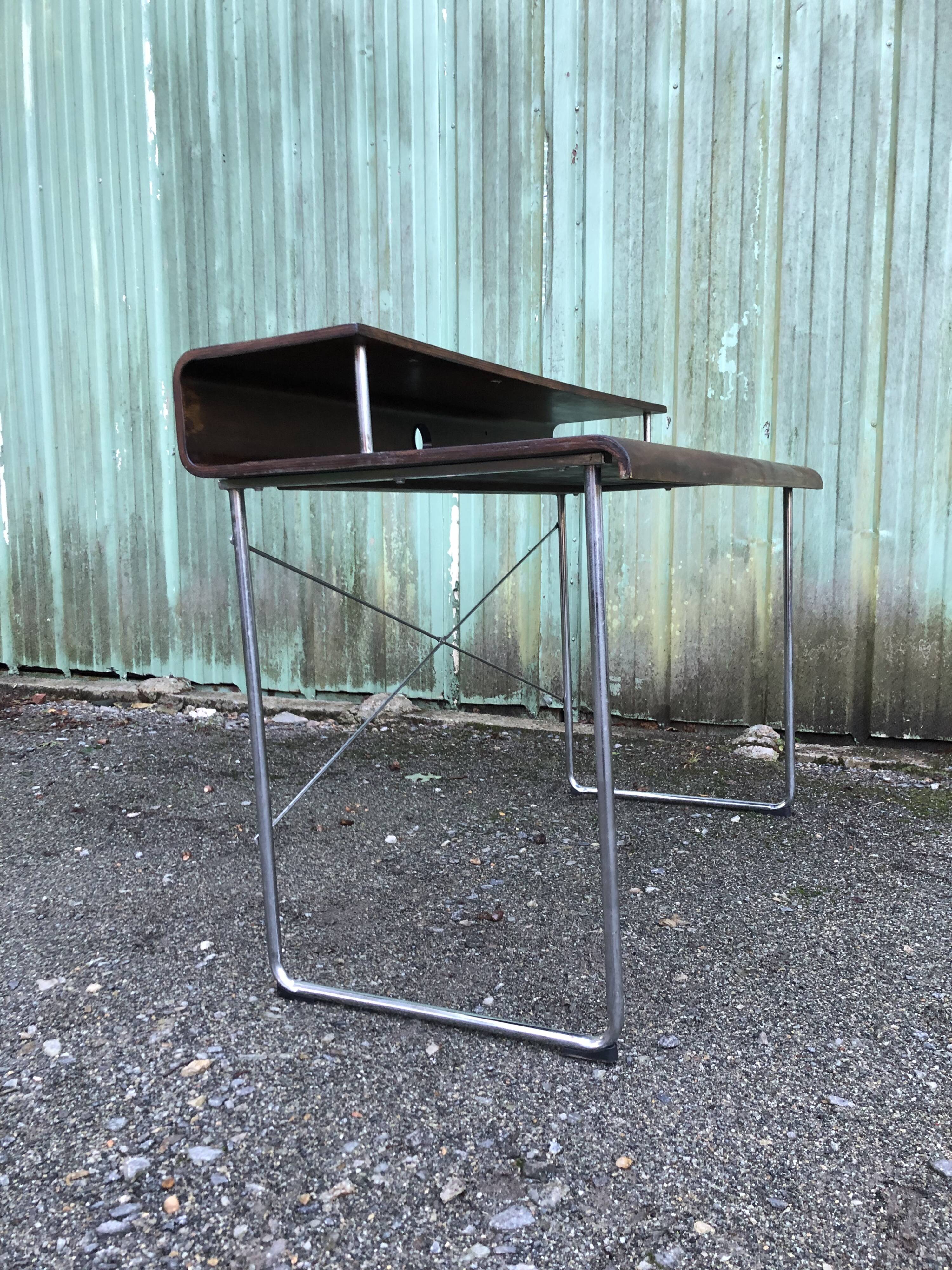 Design desk in formed glued laminated wood with chrome tubular base.