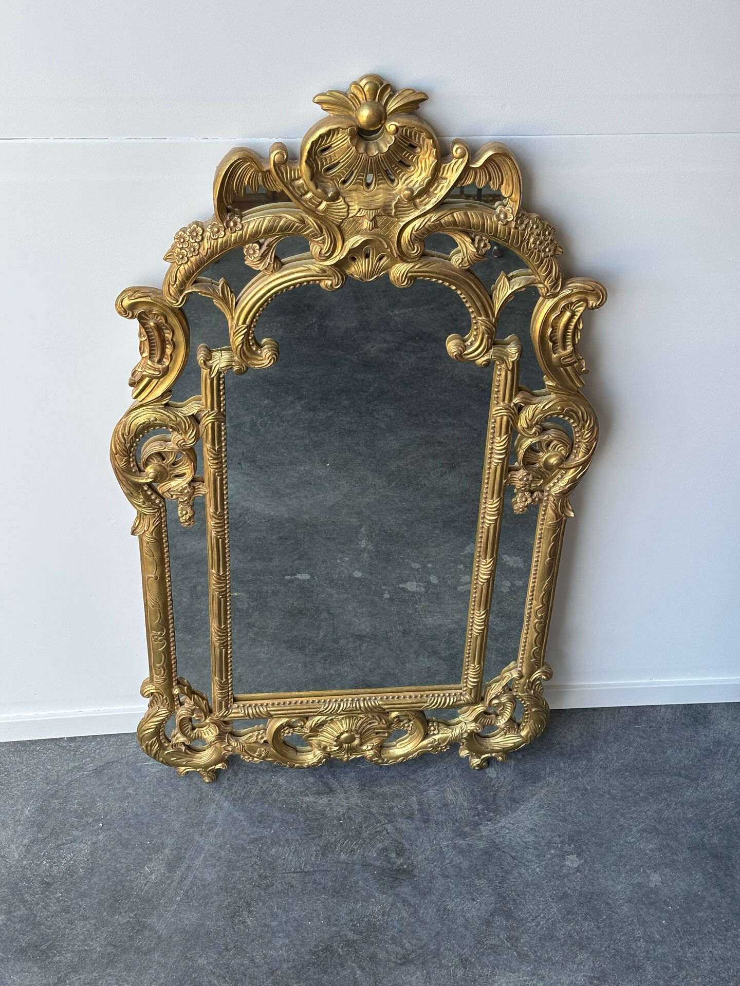 Large mirror with carved and gilded wooden frame, in Regency style.