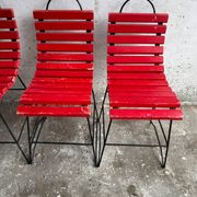 Red slatted chair with a black metal frame.