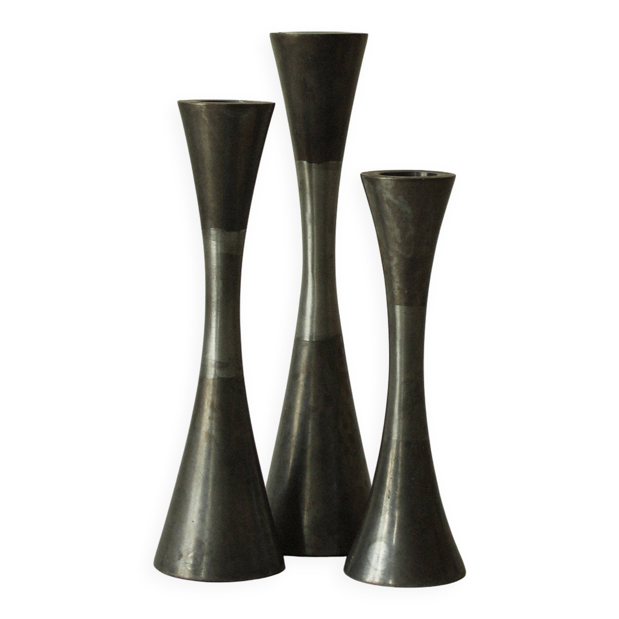 Set of three diabolo-shaped candle holders made of cast steel.