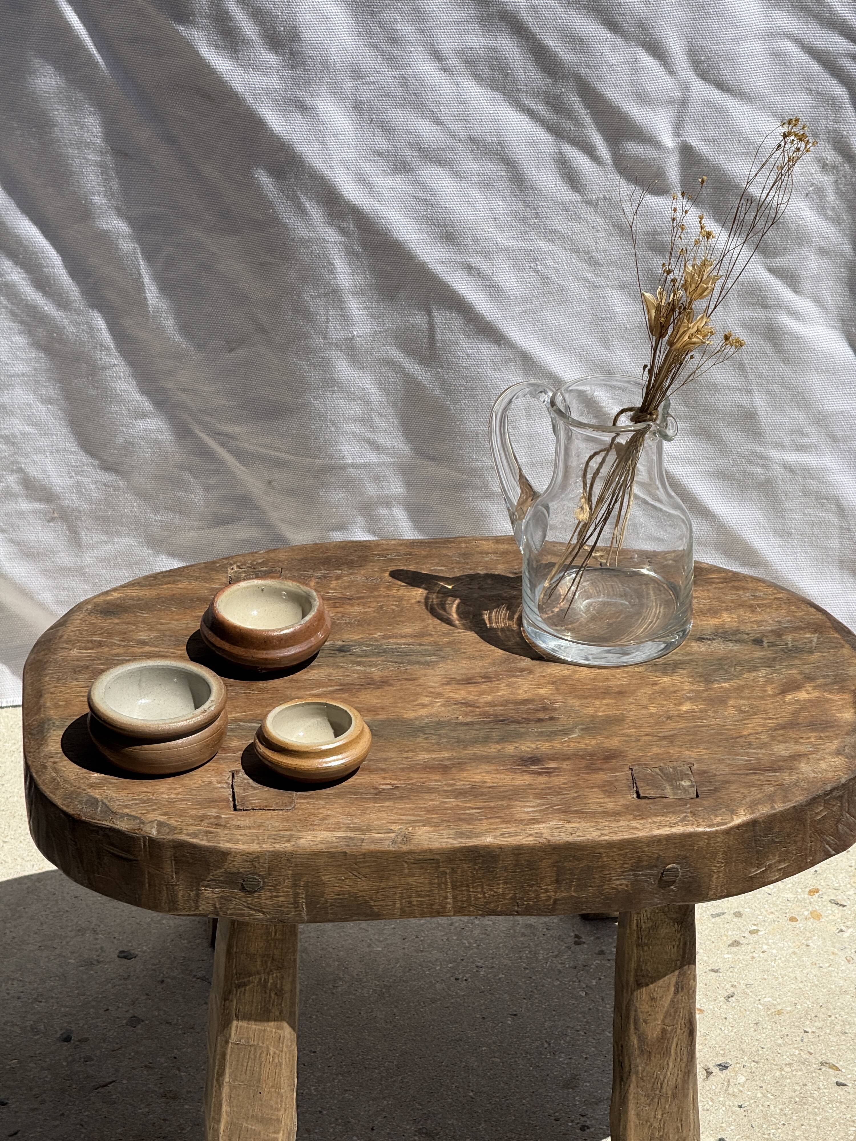 Small stool, oval solid teak side table with curved legs in wabi-sabi style.