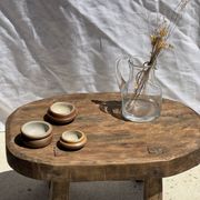 Small stool, oval solid teak side table with curved legs in wabi-sabi style.