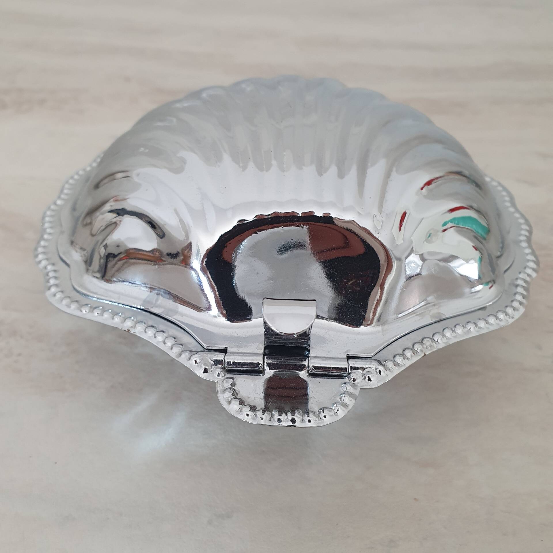Shell-shaped butter dish in stainless steel and white glass bowl.