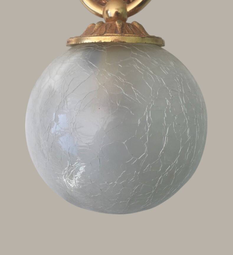 Wall light with golden hand and glass globe