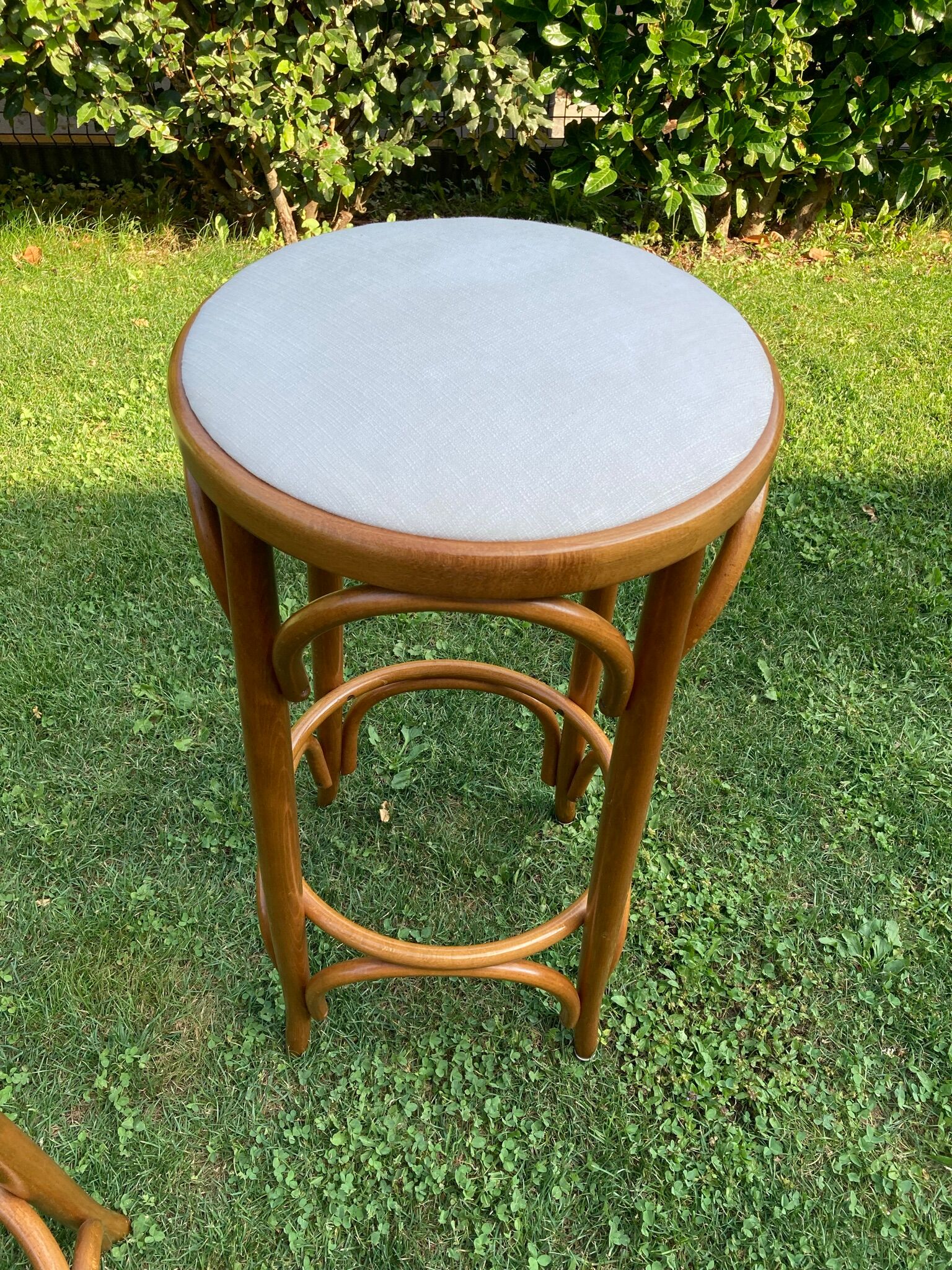 3 bar stools made of curved wood and fabric seat