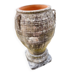 Large Cretan jar in terracotta with three handles on a stone base.