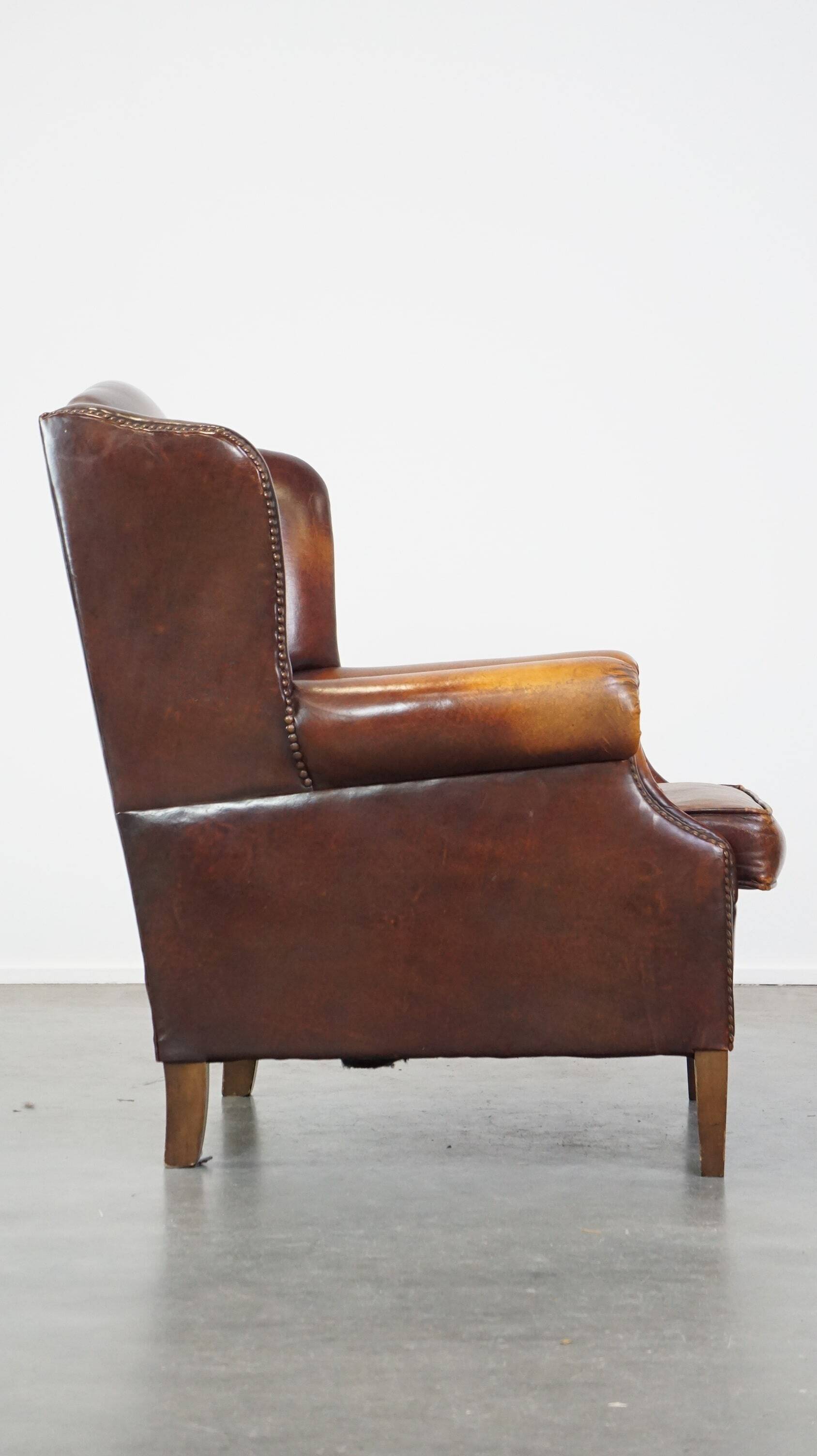 Comfortable, elegant, stately wing chair made of sheepskin in a beautiful warm color