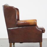 Comfortable, elegant, stately wing chair made of sheepskin in a beautiful warm color