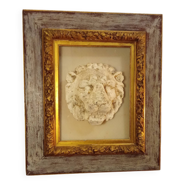 Antique gilded frame with stone lion head ornament on plexiglass