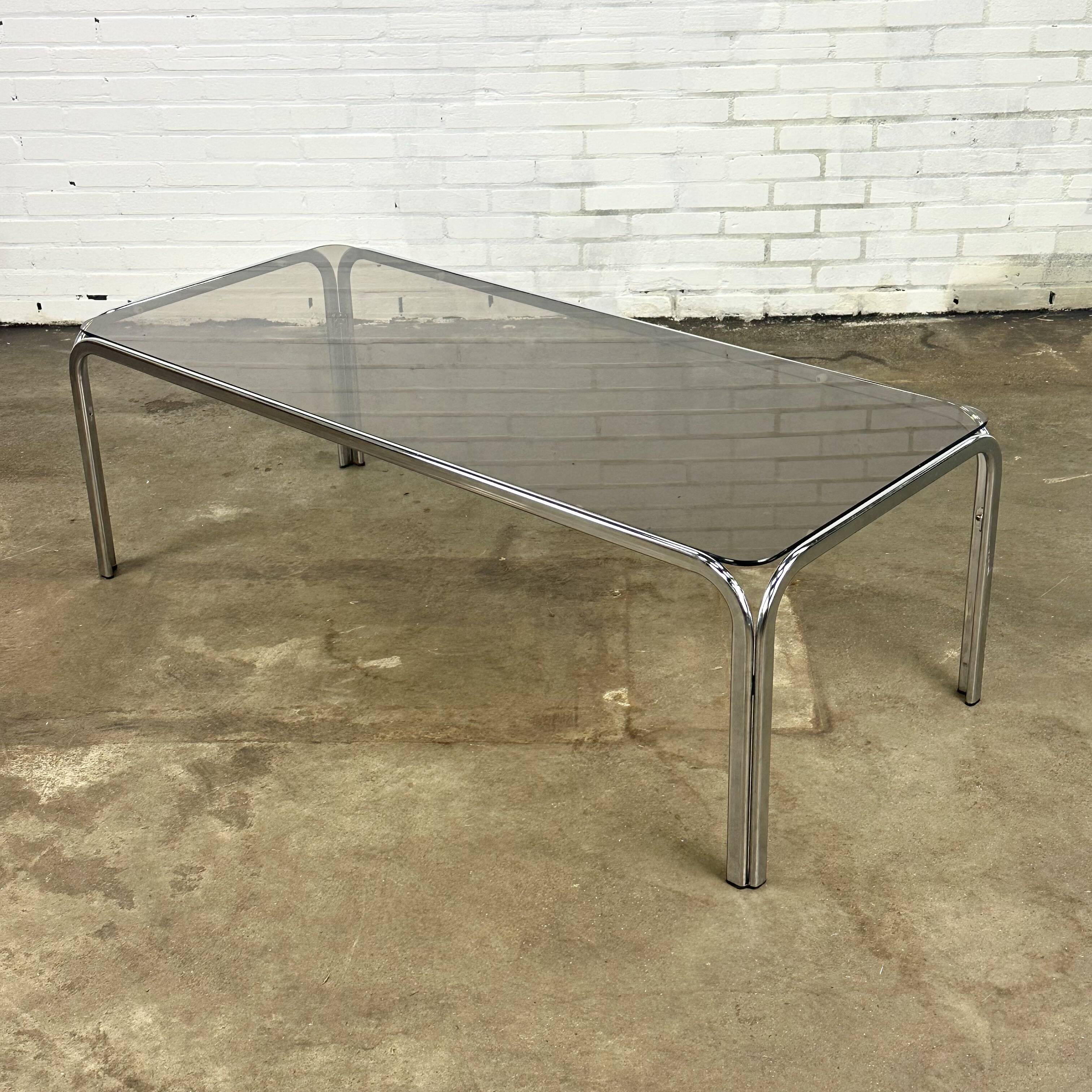 Table basse vintage à structure tubulaire et verre fumé