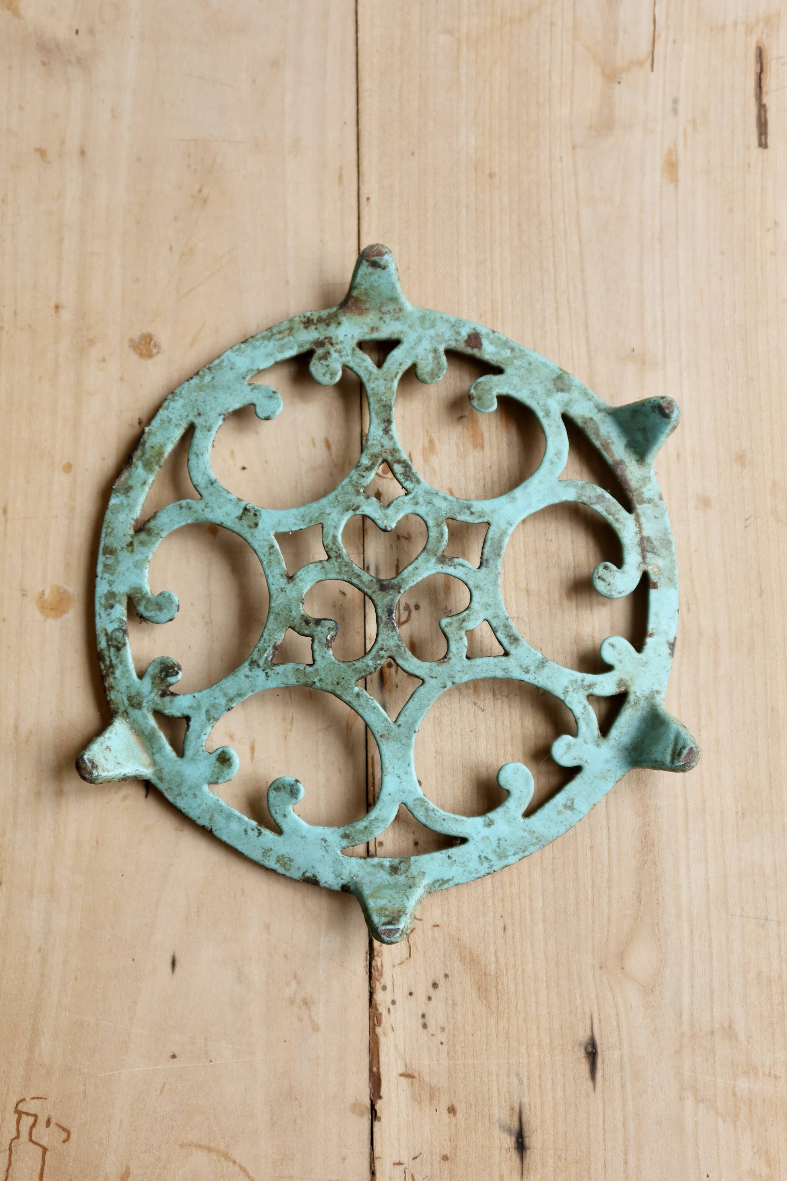 Antique round turquoise cast iron trivet.