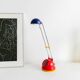 Lampe de bureau avec abat-jour en métal peint en bleu, bras articulé en chrome, style Memphis des années 80 Pop Art avec base rouge et accents jaunes.